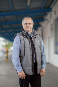 Man in grey vest and glasses