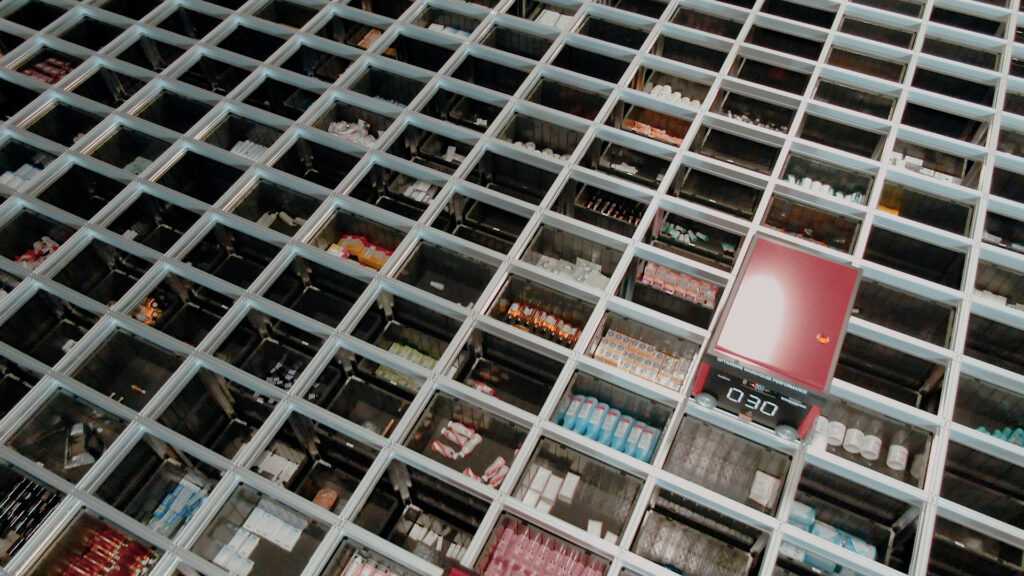 A birdseye view over the Apotea AutoStore grid with a redline robot picking orders.