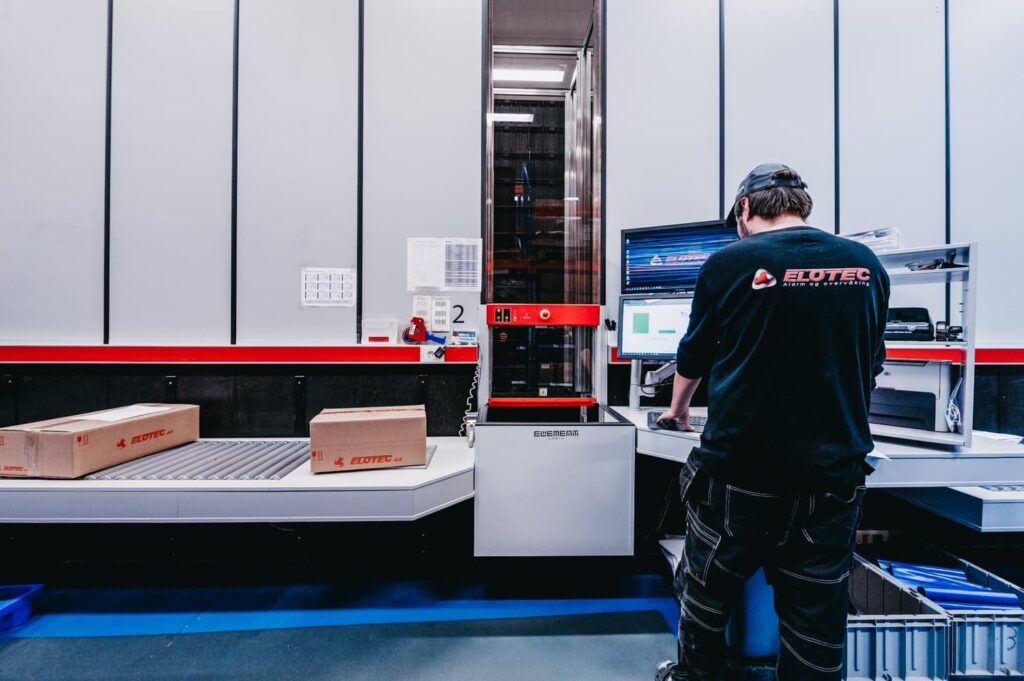 A worker is handling the orders from AutoStore in the Elotec warehouse.