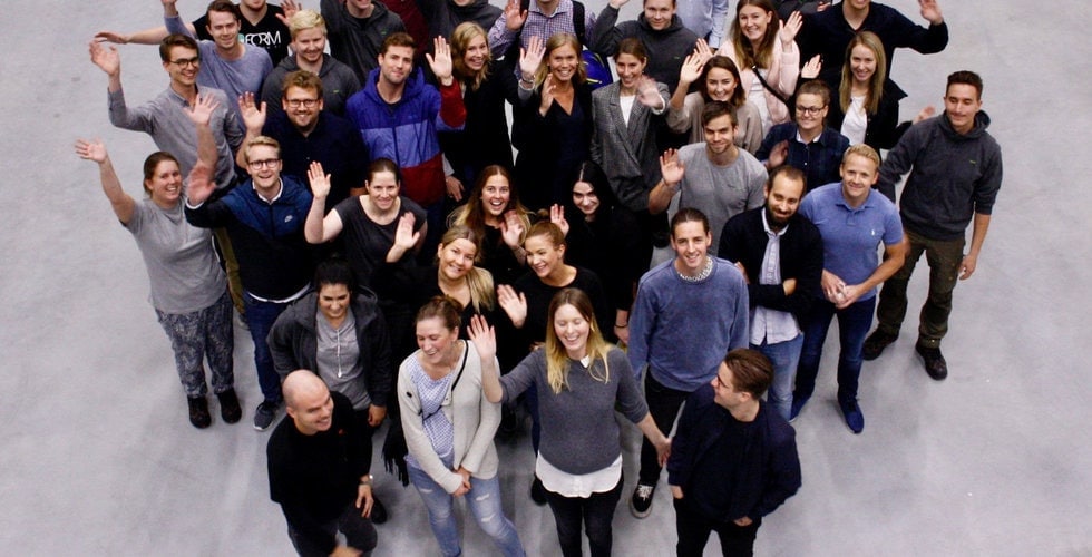 A crowd of KitchenTime employees standing together looking up towards the camera.