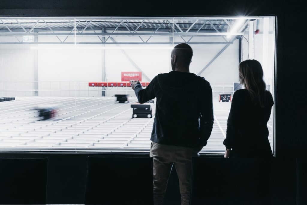 Two people standing with their backs towards the camera looking out on New Wave's AutoStore