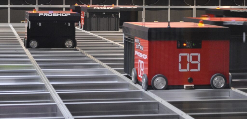 Several Proshop robots working on an AutoStore grid picking bins