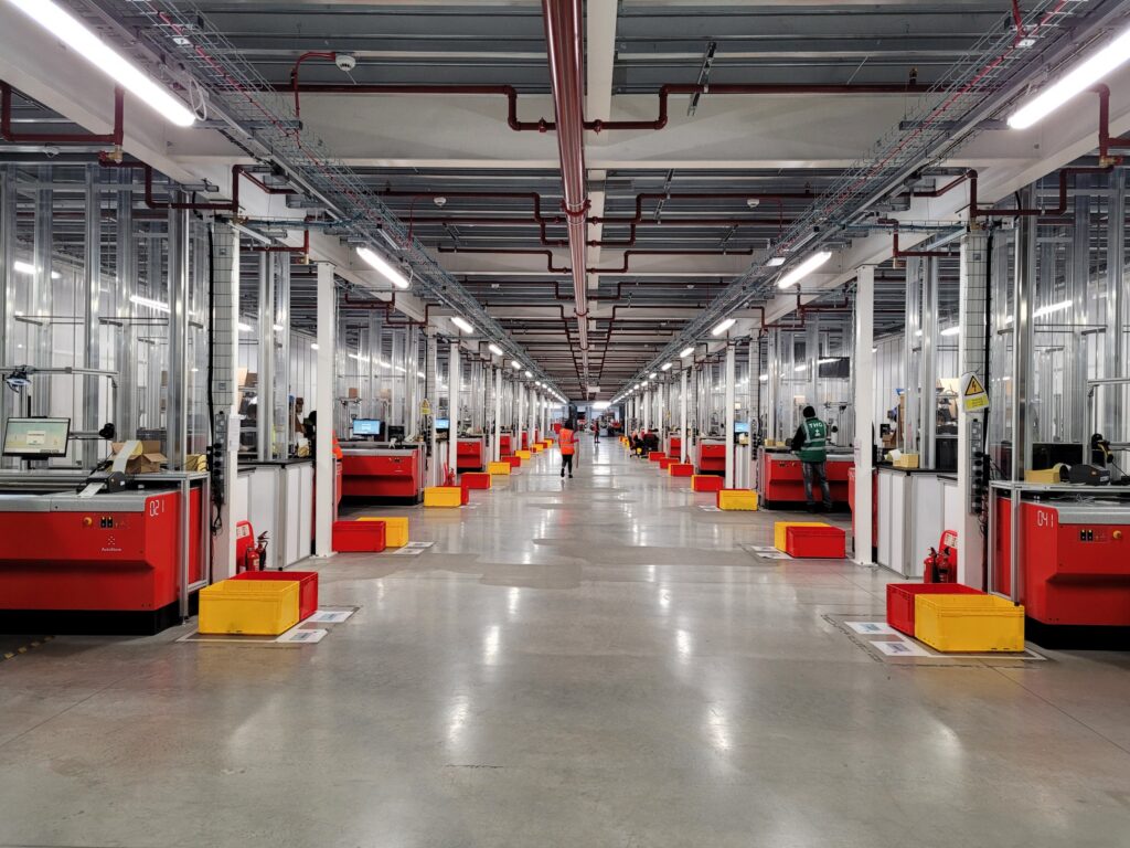 A corridor of picking stations in the TGH AutoStore warehouse from Element Logic.