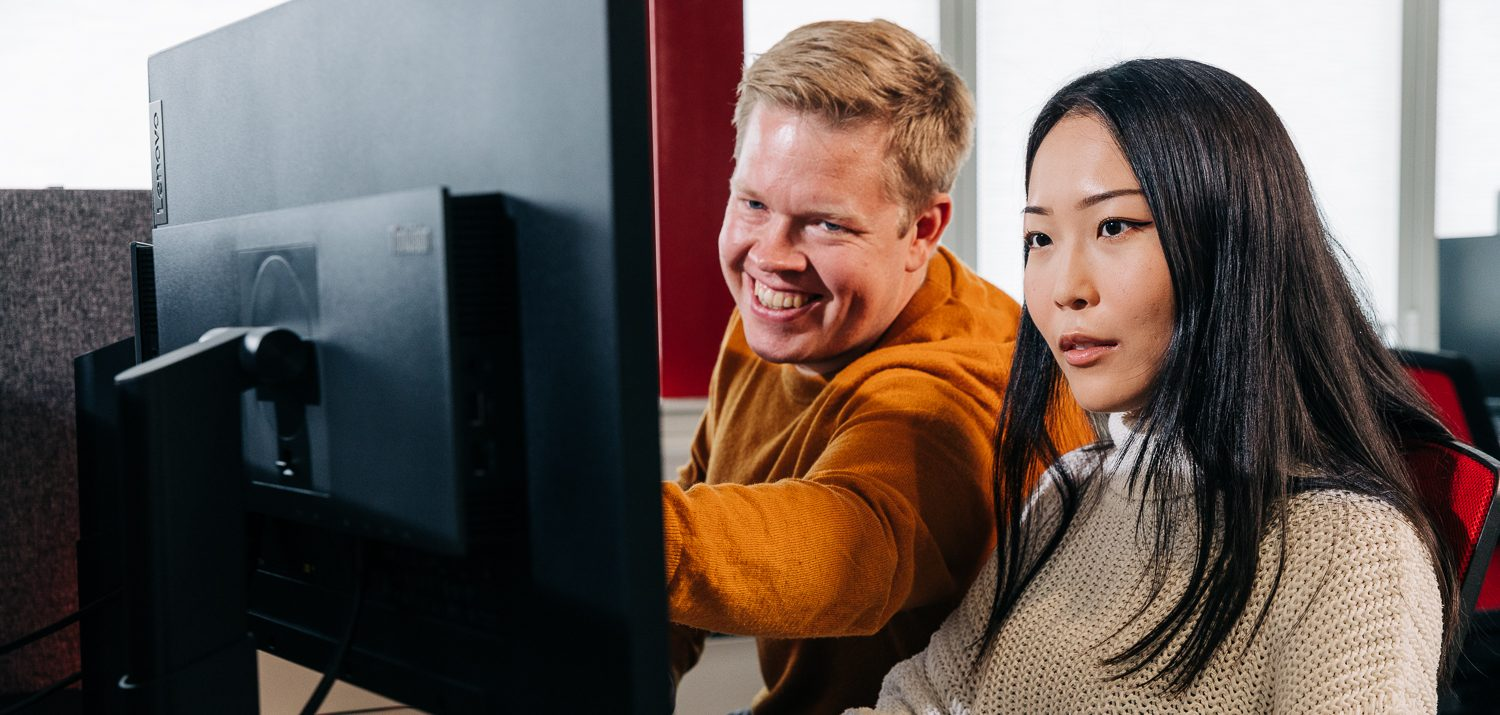 Man and woman behind screen. Man pointing and smiling