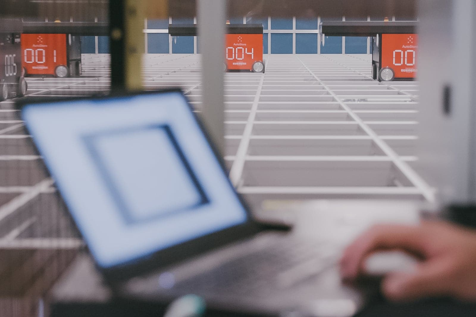 Computer infront of an automated warehouse