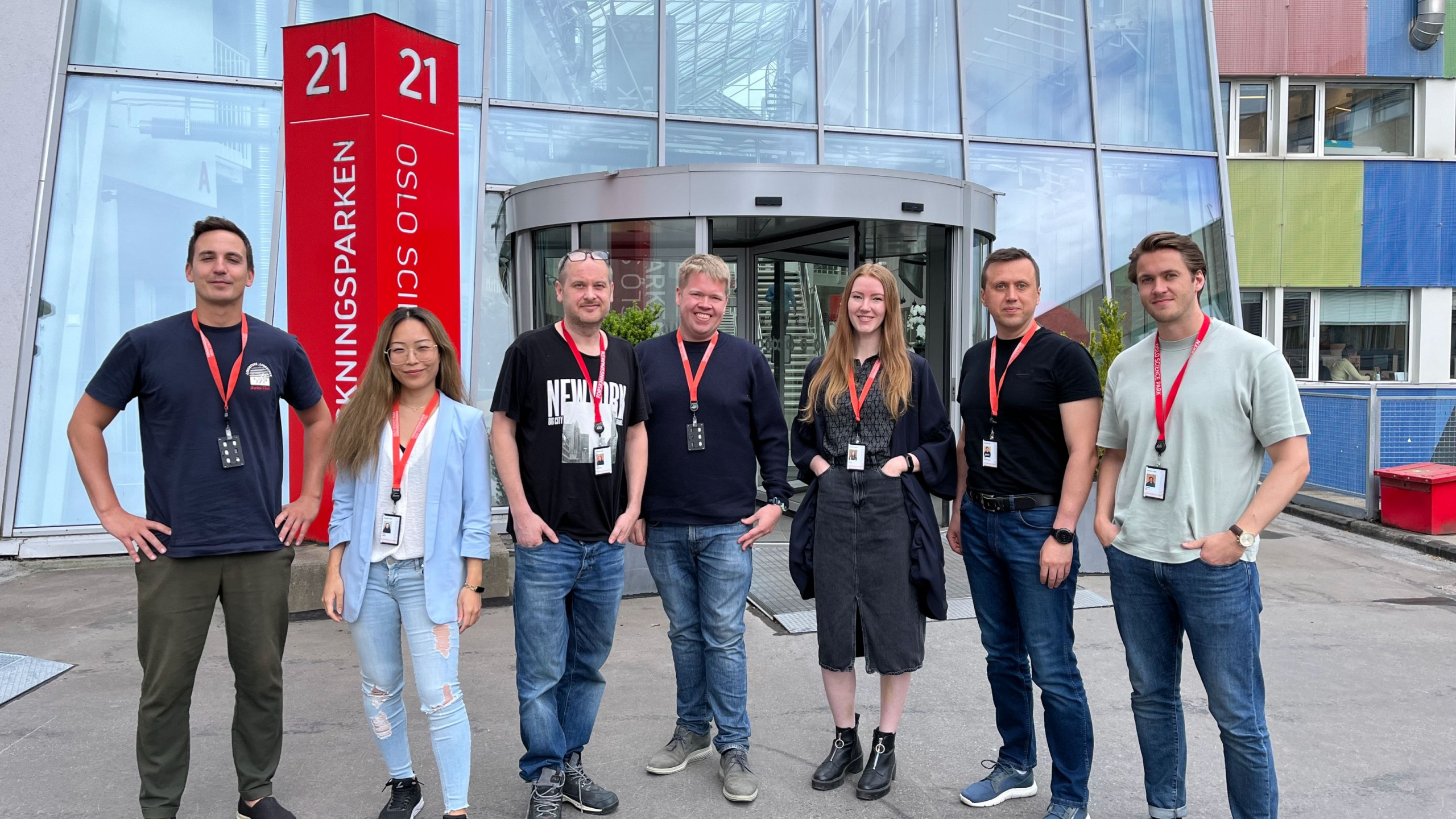 Seven people in front of a modern building