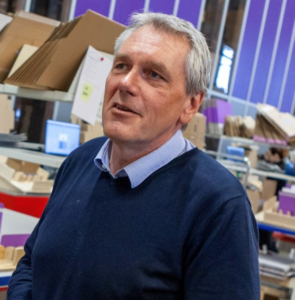 Man in front of automated warehouse