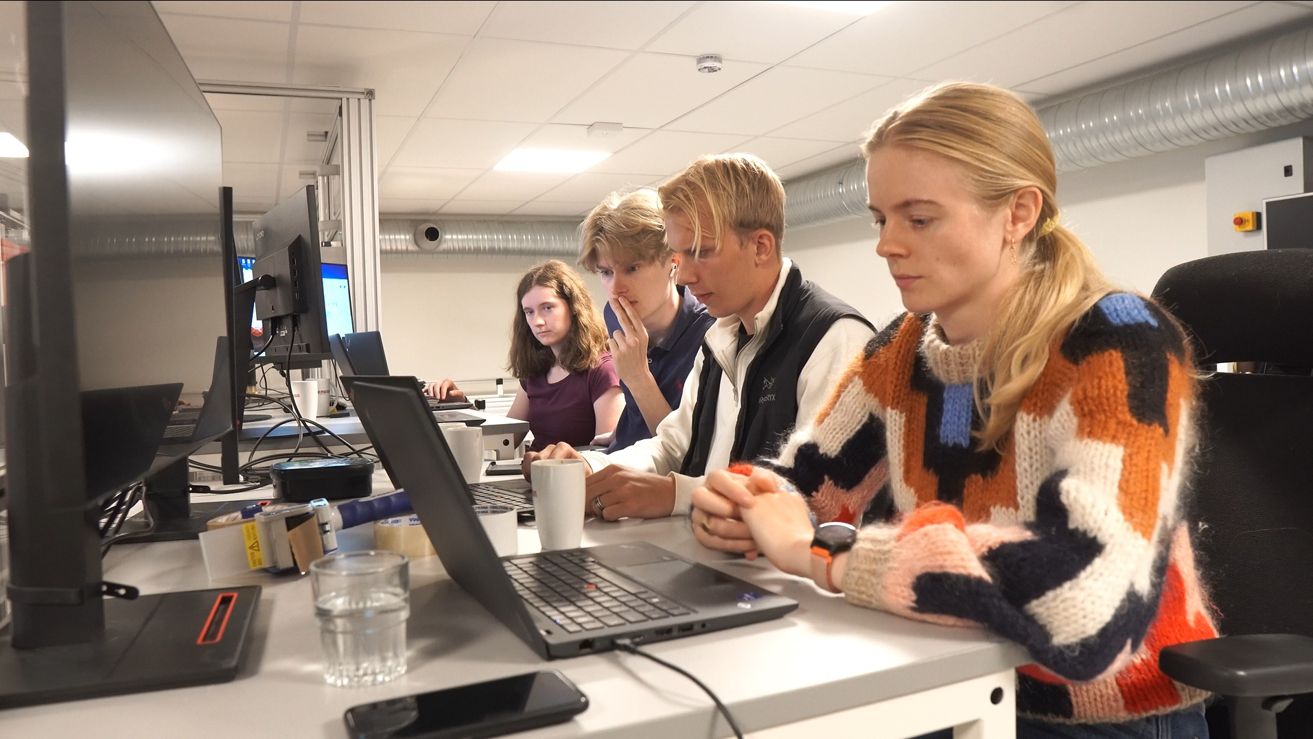 Four young men and women working on computers