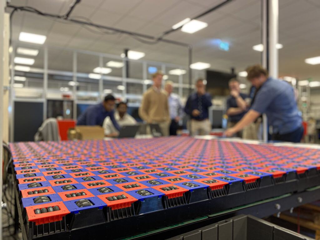 A picture of the demonstration of the internship case with the Omnimod conveyor belt in the forefront and the students and audience in the background.