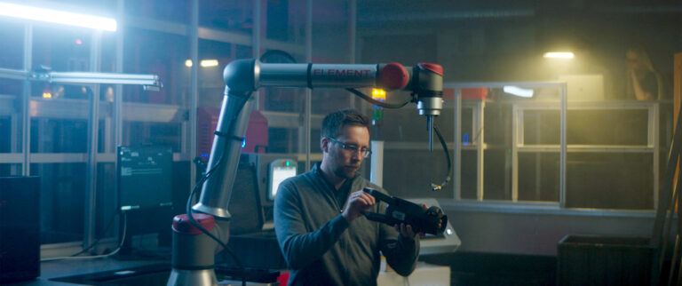 A man investigating the gripper of an automated piece-picking robot