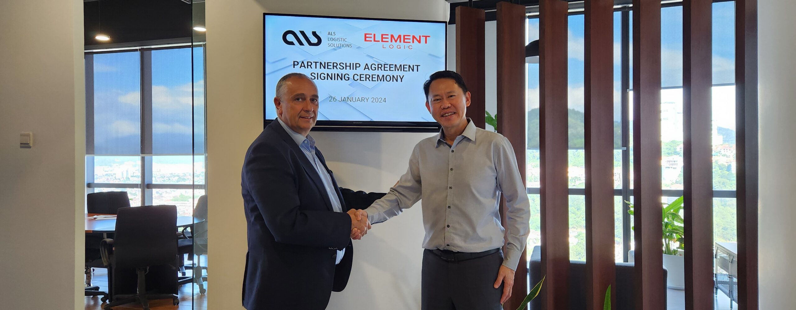 Armin Gesslein and Mr Aloysius Chin shaking hands and looking into the camera.