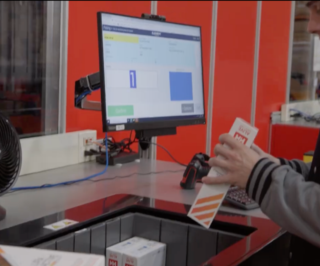 A man scanning products at the picking station.