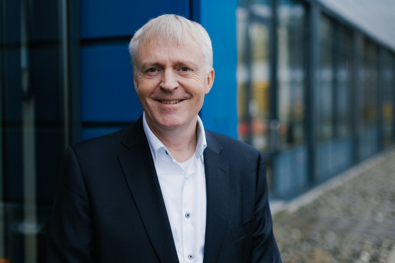 Dag-Adler Blakseth, CEO de Element Logic, sonríe frente a un edificio de oficinas.