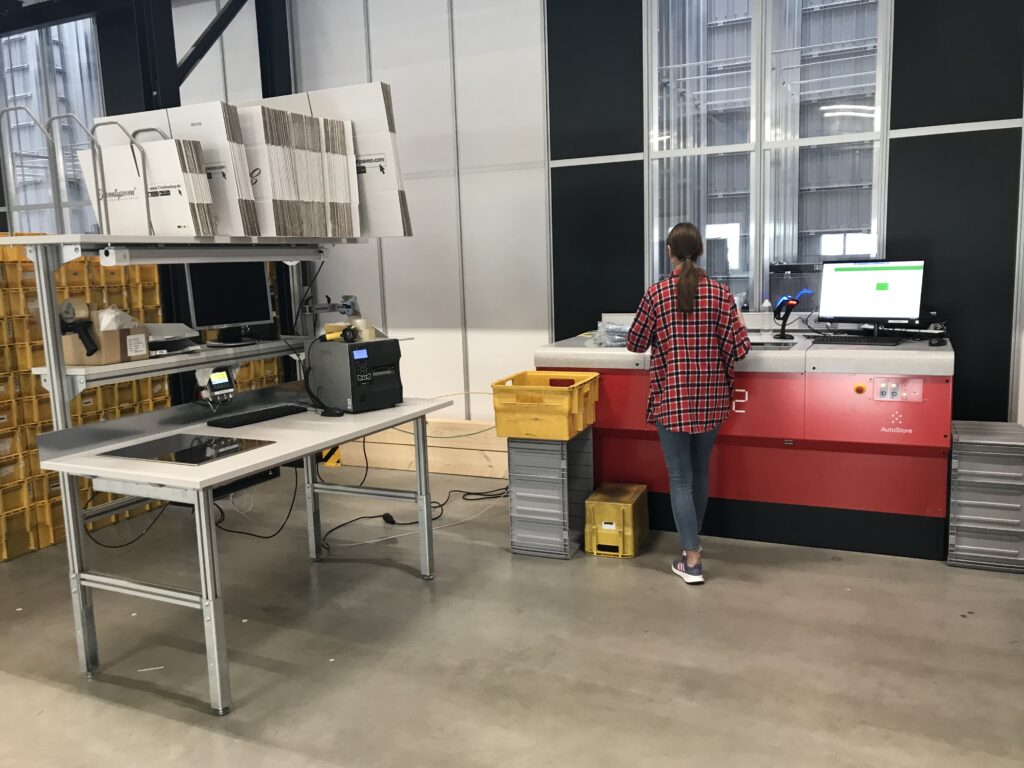 Mujer trabajando en una estación de picking de AutoStore