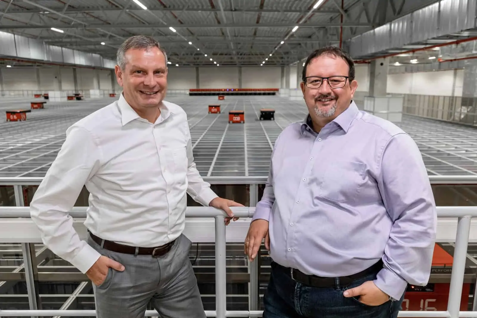 Thomas Rolle und Michael Kawalier stehen vor der AutoStore Anlage bei TTI