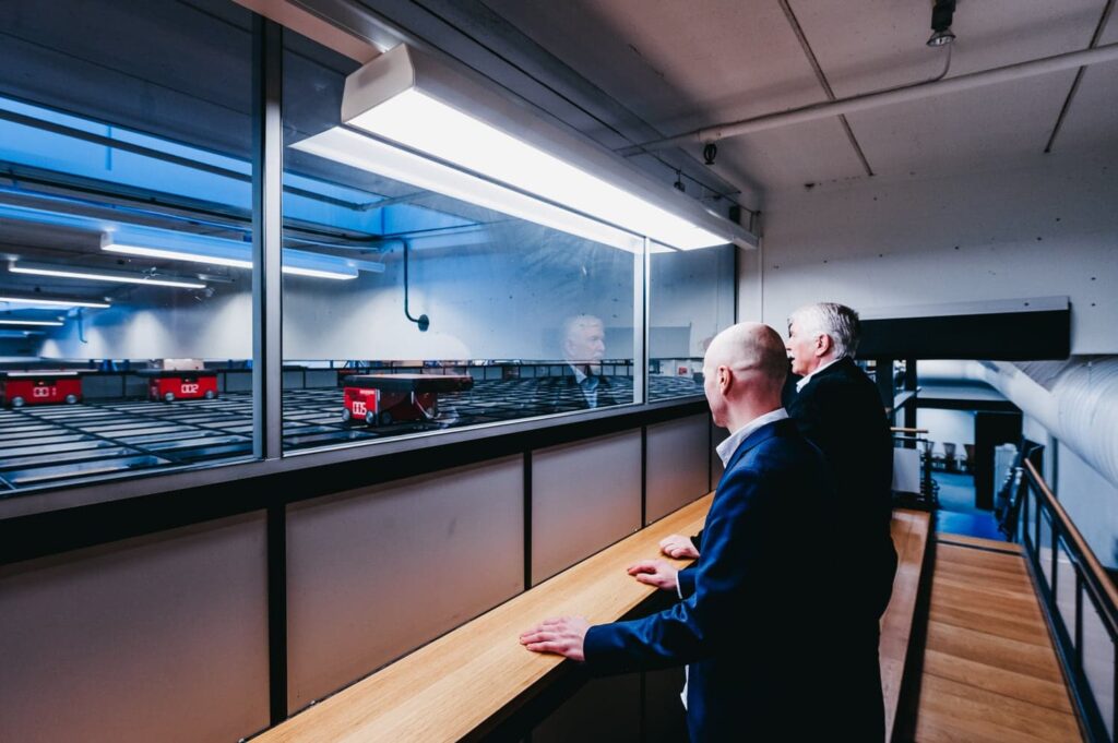 Jan Kleven e Roger Furnes osservano i robot di AutoStore sulla griglia di partenza.