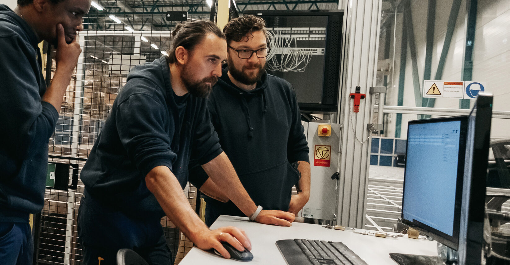 Three men working on a computer