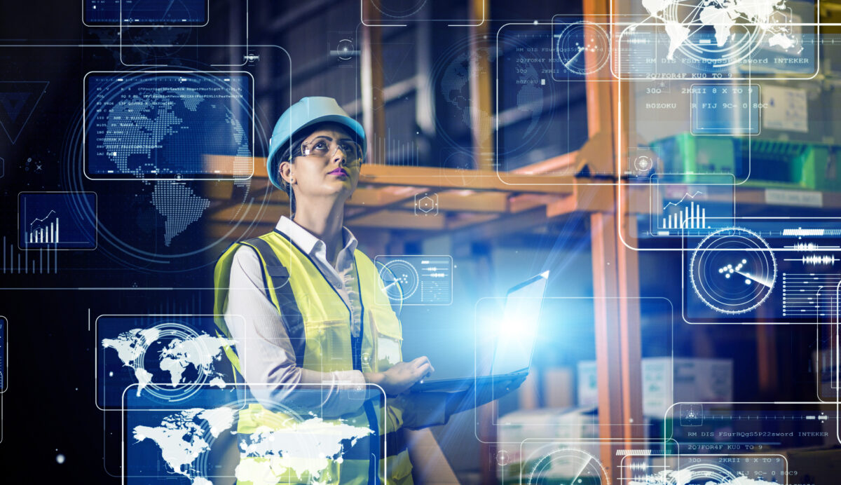 women in hard hat and safety vest holding a tablet with graphics about automation surround her