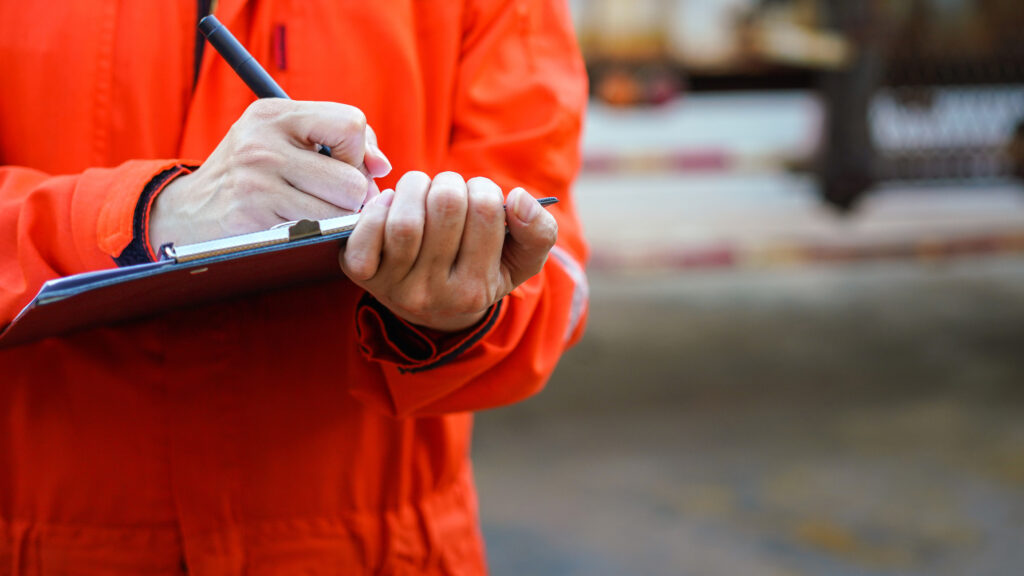 person writing down on a notepad.