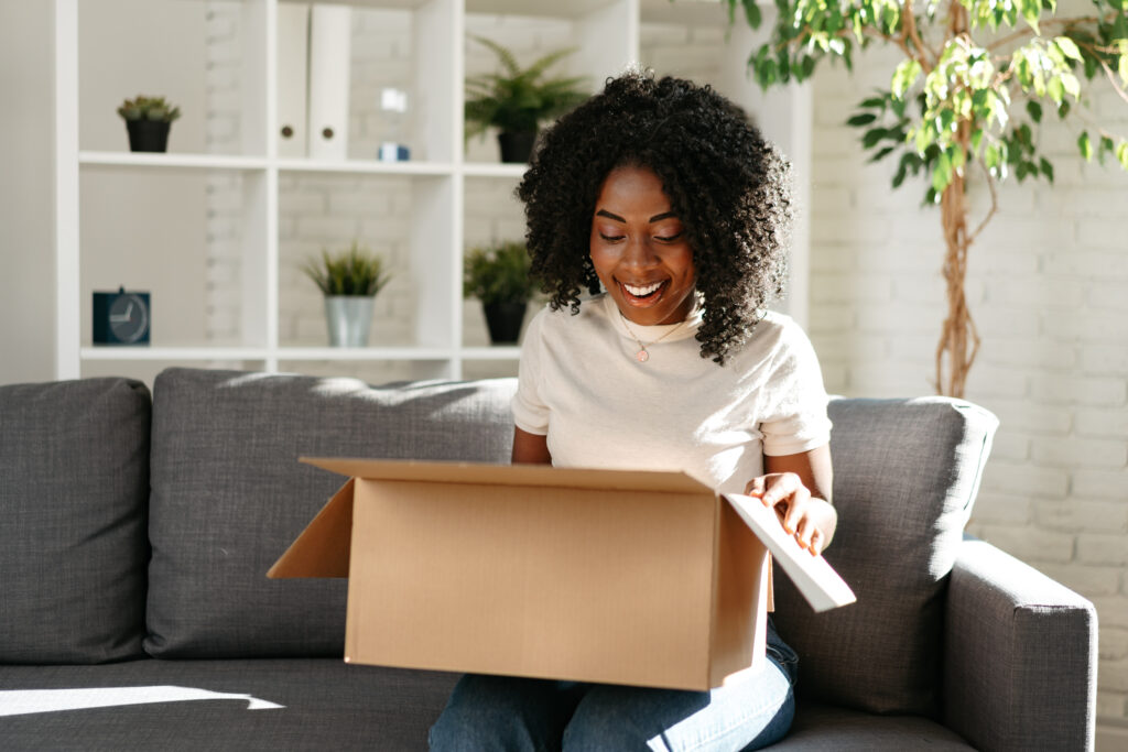 woman smiles while opening a package