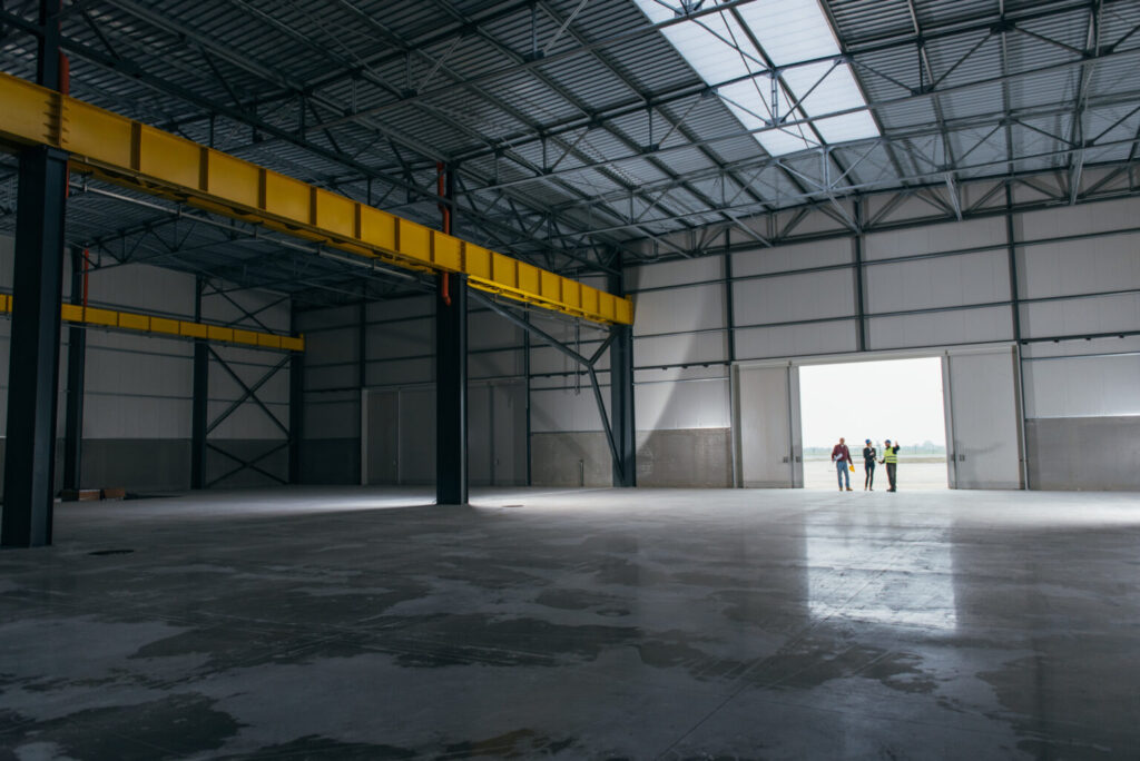 empty warehouse storage with workers in the open doorway.