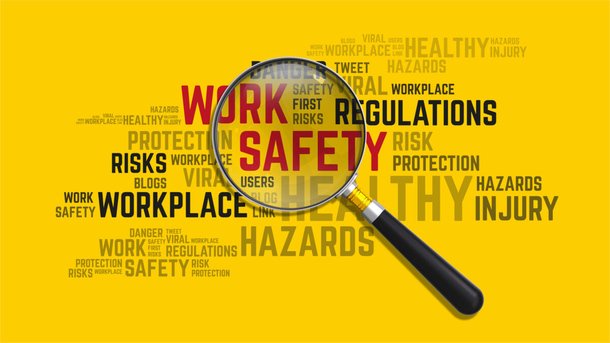 workplace safety graphic being inspected by a magnifying glass.