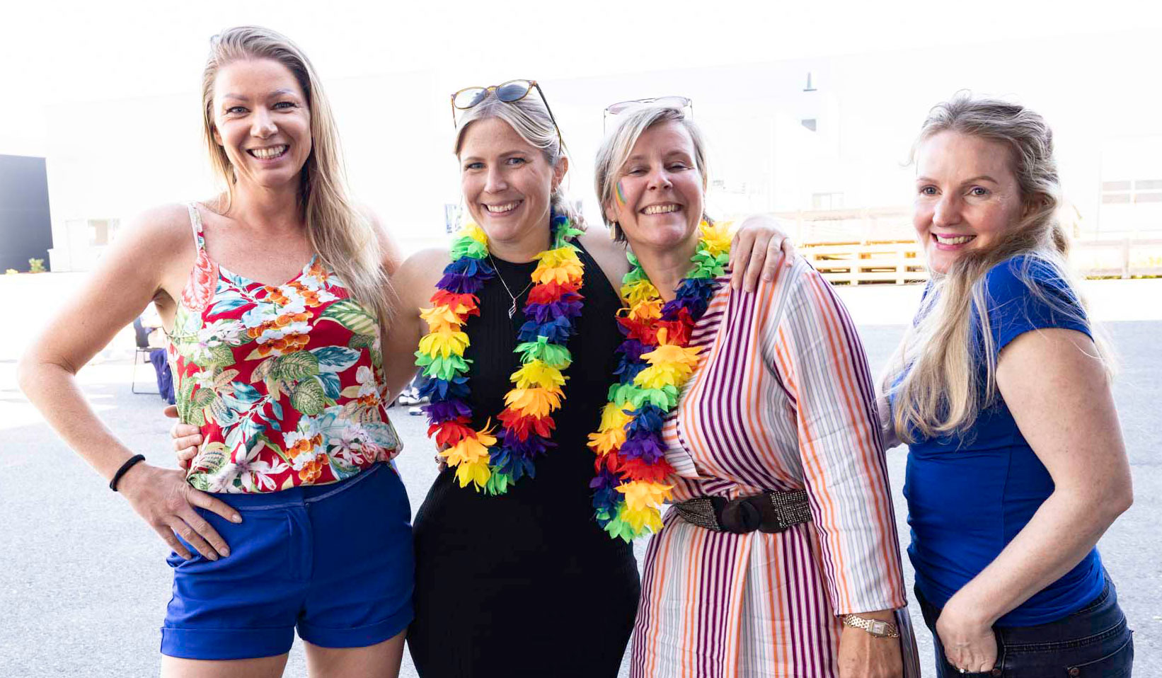 Four women standing together smiling to the camera